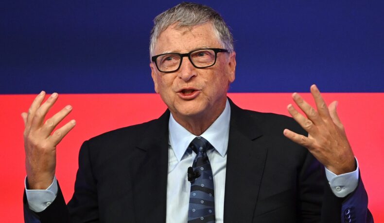Bill Gates, pe scena Global Investment Summit, 2021, Science Museum. Poartă un costum negru, cămașă albă, cu albastru și roșu pe fundal. Vila „de burlac” a lui Bill Gates deranjează vecinii